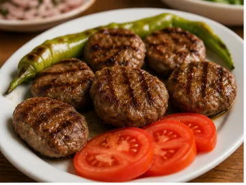 Izgara köfte, domates ve yeşil biber ile servis